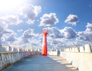 Photo of a lighthouse and concrete block breakwater. clipart