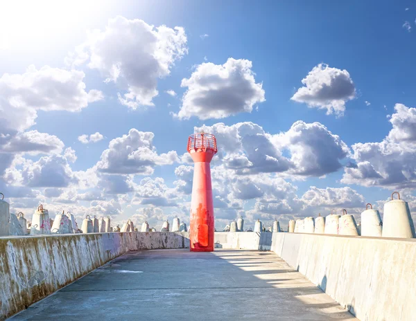 Foto eines Leuchtturms und einer Wellenbrecher aus Betonklötzen. — Stockfoto