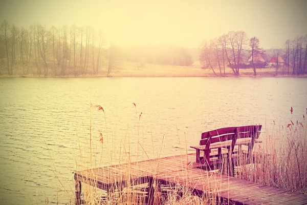 Vintage foto estilizada de banco en el lago . — Foto de Stock