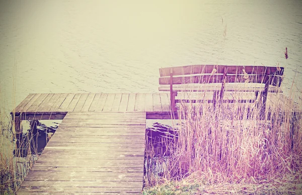 Vintage gestileerde foto van een houten bank aan het meer. — Stockfoto