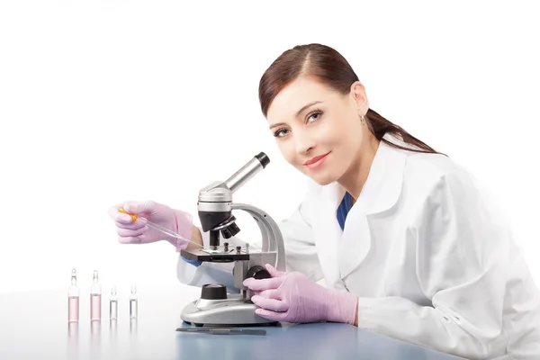 Mujer usando un microscopio en un laboratorio . — Foto de Stock