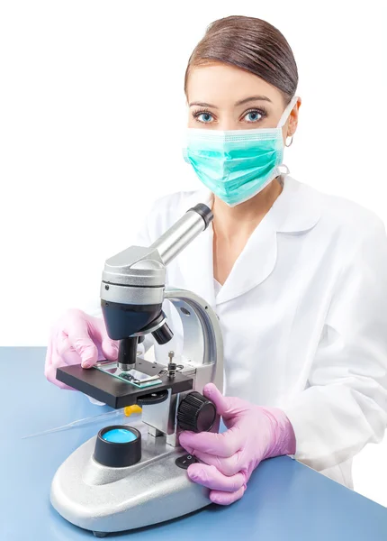 Mujer usando un microscopio en un laboratorio . — Foto de Stock