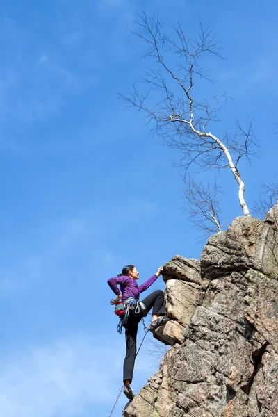 Vrouwelijke rock klimmer op een klif. — Stockfoto