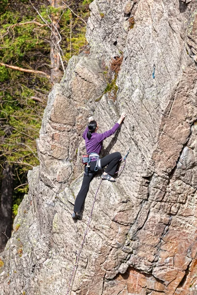 Vrouwelijke rock klimmer op een klif. — Stockfoto