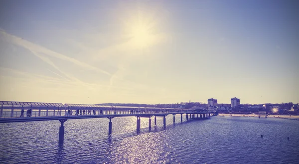 Vintage afgezwakt pier tegen zon. — Stockfoto