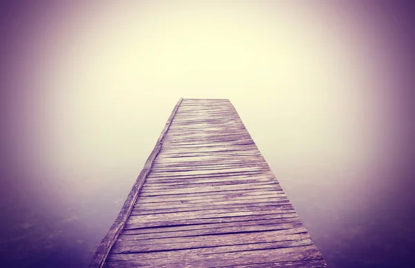 Imagen filtrada vintage de muelle de madera viejo y niebla densa . —  Fotos de Stock