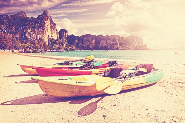Retro toned kayaks on a tropical beach. — Zdjęcie stockowe
