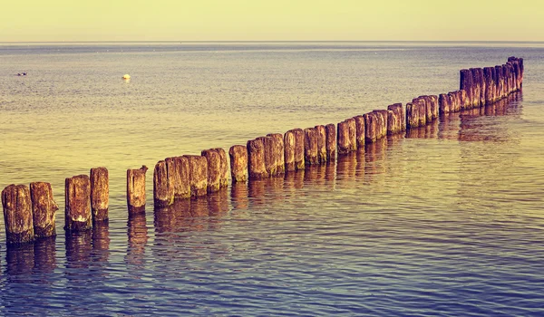 Retro getönte Holzpfosten am Strand. — Stockfoto