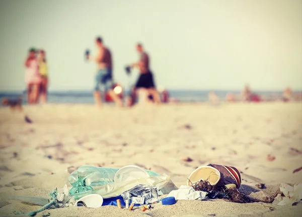 Spazzatura filtrata retrò su una spiaggia lasciata dai turisti . — Foto Stock