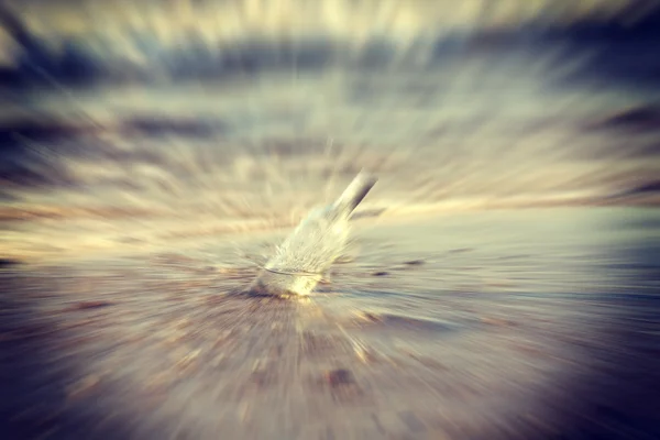 Retro toned motion blurred bottle of vodka in water. — Stock Photo, Image