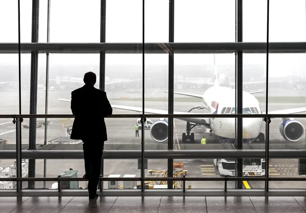 Silhouet van een reiziger die wachten op een vliegtuig. — Stockfoto