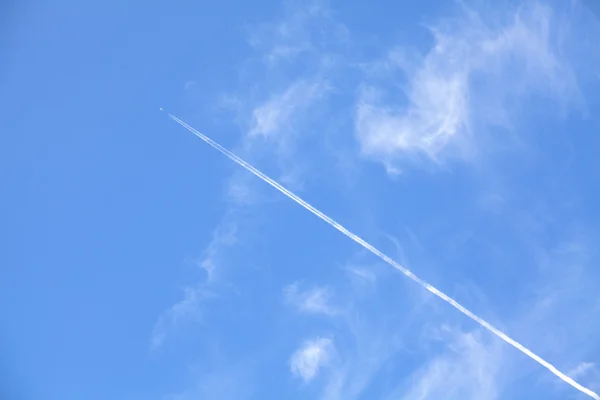 繊細な雲の美しい青い空と飛行機飛行機雲 — ストック写真