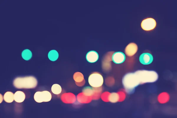 Vintage toned blurred city lights at night, urban abstract backg — Stock Photo, Image
