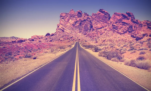 Retro stylized road through rocky desert, Nevada. — Stock Photo, Image