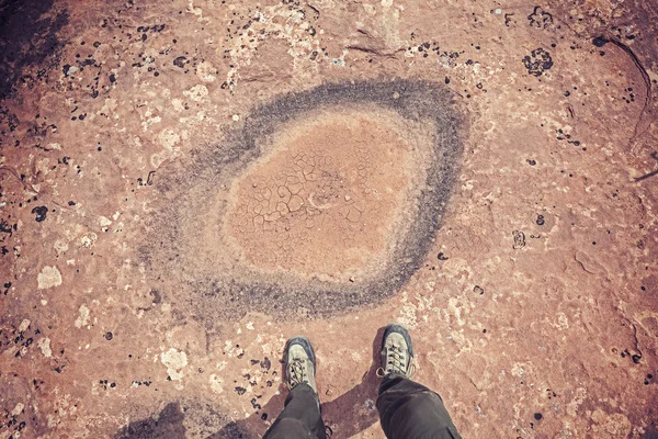 Pieds debout devant une flaque d'eau desséchée . — Photo