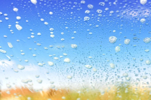 Sfondo astratto fatto di bolle di sapone sfocate su vetro . — Foto Stock
