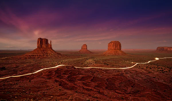 Luces de coche senderos en Monument Valley por la noche, EE.UU. . —  Fotos de Stock