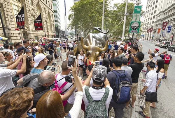 Turister som tar bilder av laddning tjuren i Bowling Green Park. — Stockfoto