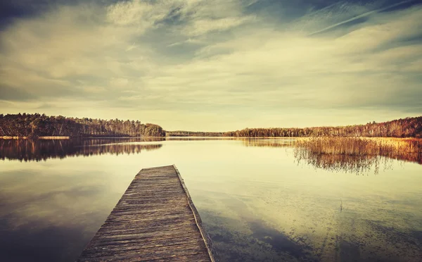 Imagen estilizada vintage de un lago y un muelle de madera . — Foto de Stock