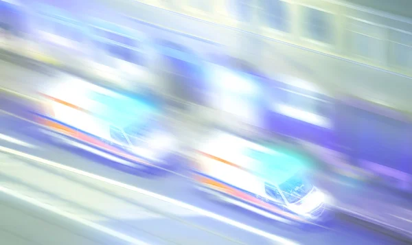 Motion blurred ambulances with flashing lights at night. — Stock Photo, Image