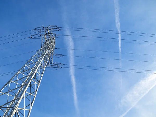 Alta tensão pilão contra o céu azul — Fotografia de Stock