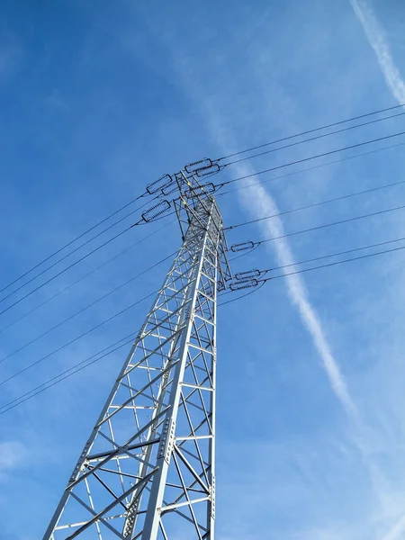 Alta tensão pilão contra o céu azul — Fotografia de Stock