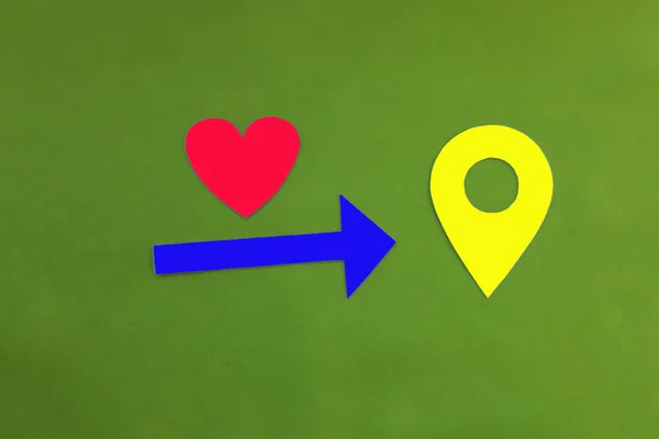The heart is red, the arrow is blue, and the geolocation sign is yellow on a green background.  The desire to find what you want. Love, long-distance relationships.