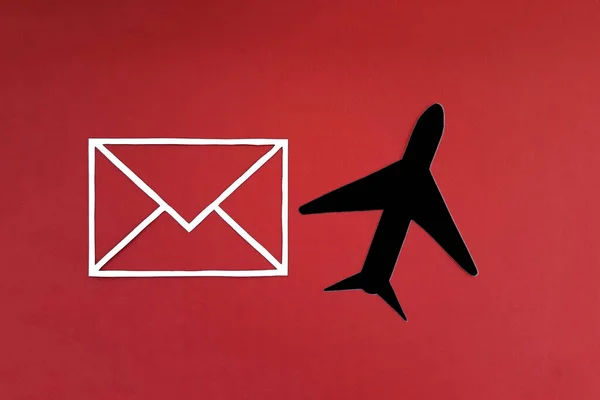Postal envelope, black plane on a red background. Delivery, departure.