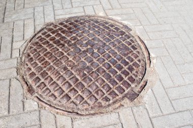 Iron manhole on the road. Housing communications, infrastructure.