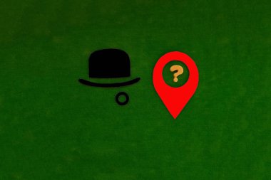 Melon şapka siyah, konum belirleme işareti kırmızı ve soru işareti yeşil arka planda sarı. İzleme teknolojileri, konum tespiti.