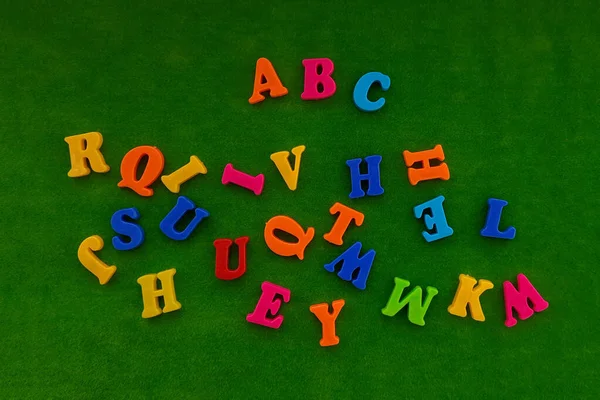 English alphabet letters are multicolored on a green background. Training, school.