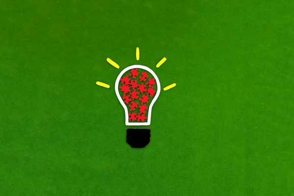 Electric light bulb, red puzzles on a green background.  Creative thoughts. Business idea. Creativity. mind.