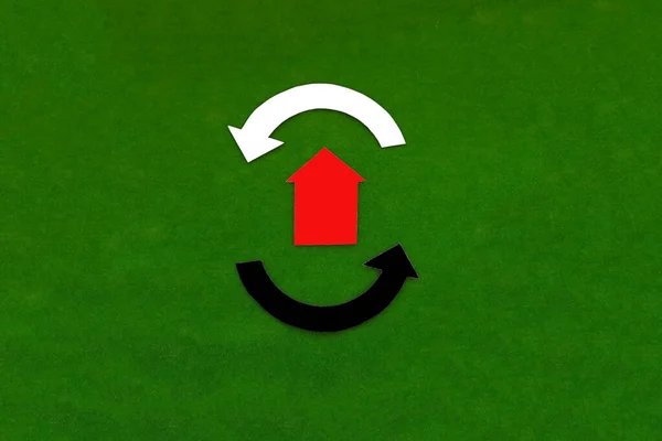 The house is red, with round arrows in white and black on a green background. Real estate turnover. Housing market.