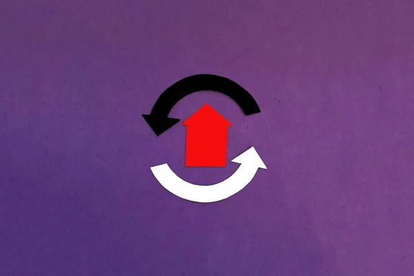 the house is red, with two rounded arrows in white and black on a purple background. Real estate market turnover. Housing for sale.
