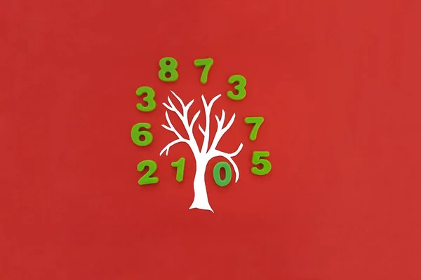 Árbol Con Una Corona Forma Números Verdes Sobre Fondo Rojo Imagen de archivo