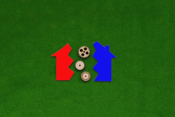 房子的两半是蓝色和红色的木制齿轮 背景是绿色的 共有所有权 房地产市场 — 图库照片