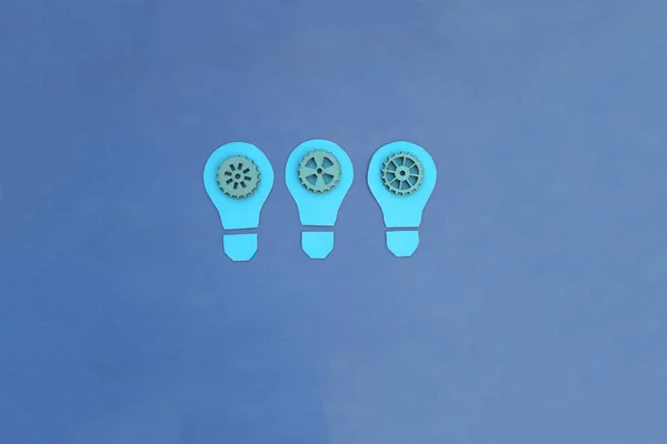 Tres Bombillas Eléctricas Engranajes Sobre Fondo Azul Equipo Pensando Ideas — Foto de Stock