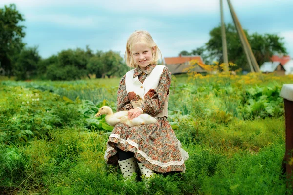 Little girl in the village with a duck — Stock Photo, Image