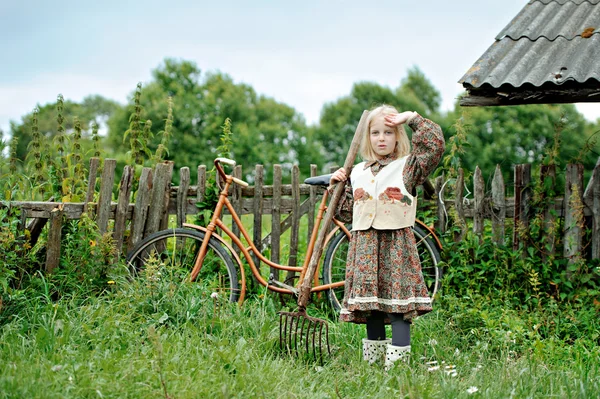 En tjej med en cykel i byn — Stockfoto