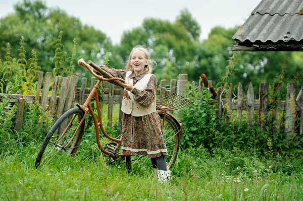 Une fille avec un vélo dans le village — Photo