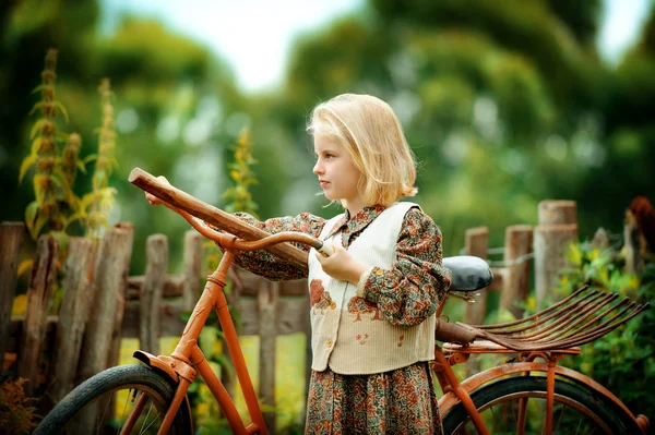 Ein Mädchen mit einem Fahrrad im Dorf — Stockfoto