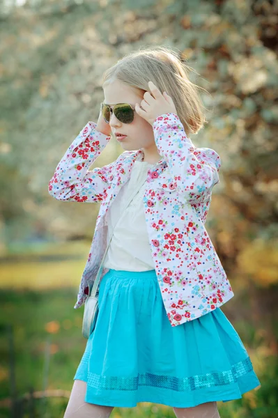 Beautiful happy little girl  enjoying smell in a flowering sprin — Stock Photo, Image