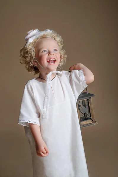 Χαριτωμένο κοριτσάκι απομονωθεί σε μπεζ φόντο με ένα flashligh — Φωτογραφία Αρχείου
