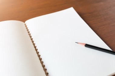 Kalem boş Not defteriyle ahşap masa arka plan kavramı üzerinde bir