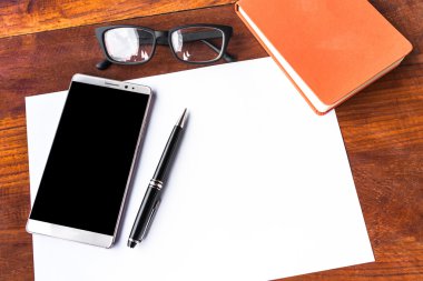 Boş kağıt kalem ve smartphone ahşap masa kavramı ve kimliği ile
