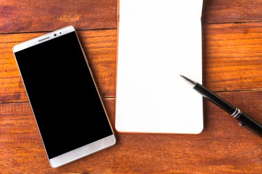 Boş kağıt kalem ve smartphone ahşap masa kavramı ve kimliği ile