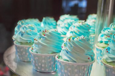 Krem ve tepesi üstte mavi cupcake