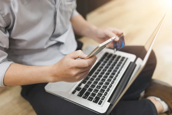 Man håller ett kreditkort och använder pc eller laptop för online s — Stockfoto