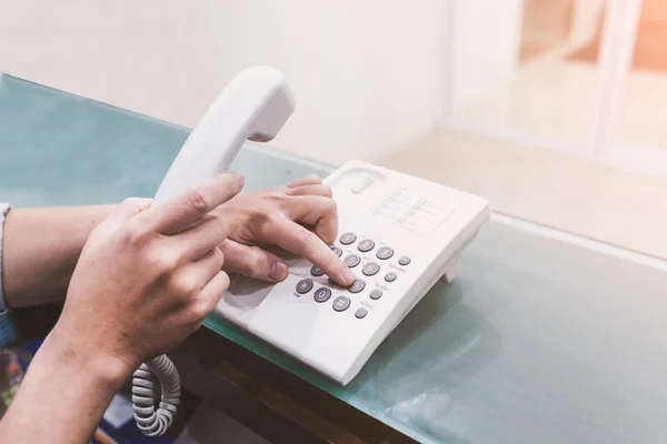 İnsan elinden telefon kolu tutan ve çevirme
