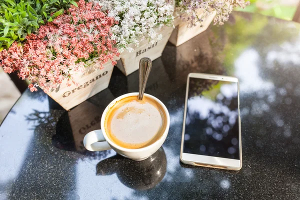 Dijital smartphone ve kahve masasında vintage çiçek — Stok fotoğraf
